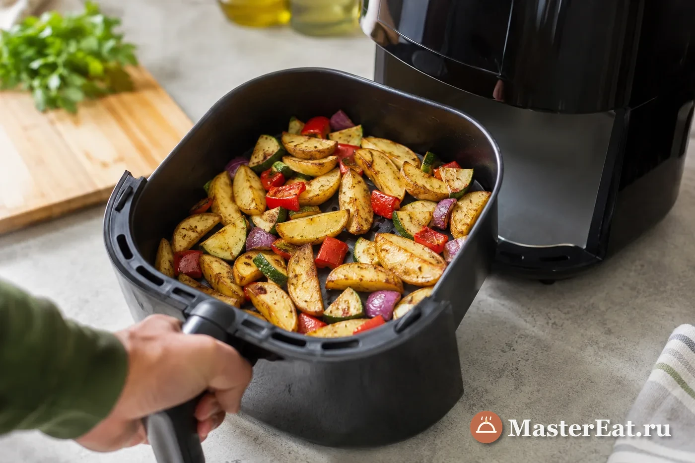 Открытая корзина аэрогриля с картофелем и овощами
